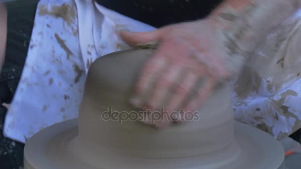 Potter está moldando pedaço de barro em um trabalhador de rodas está fazendo um pote masculino mãos sujas artesão ao ar livre show no Festival de altas temperaturas em Wroclaw — Vídeo de Stock