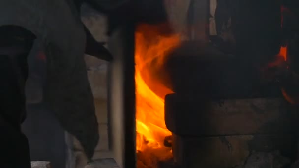 粘土和搪瓷燃烧中的人将那块木头放入火工人在砖炉安全服装秀在电影节的最高温度的弗罗茨瓦夫 — 图库视频影像