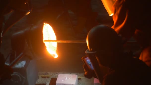 Εργαζόμενοι χύτευση ένα υγρό μέταλλο, το ρίχνει έξω από κουτάλα σιλουέτες σε κλιβάνους Φεστιβάλ από υψηλές θερμοκρασίες σε Βρότσλαβ τεχνίτες στο αστικό τοπίο νύχτα — Αρχείο Βίντεο