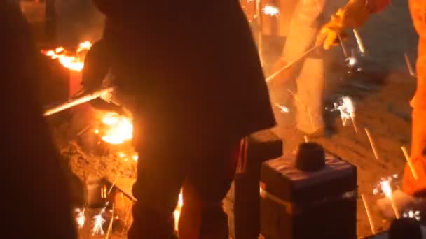 Trabalhadores lançam um Metal Líquido nos Moldes Metal Laranja Brilhante Brilhando no Show noturno no Festival de Alta Temperatura em Wroclaw na Praça da Cidade — Vídeo de Stock