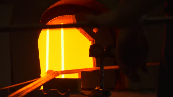 Artisanat met un détail de verre dans la flamme soufflant four Silhouette de l'homme Festival des hautes températures Les gens montrent des compétences Technique de formage du verre 