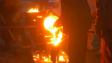 İşçiler LIT, gece Cityscape döküm kalıpları içine bir Metal siluetleri döküm açık havada Fuarı'nda Festival yüksek sıcaklıklarda dökme sıvı Metal tarafından