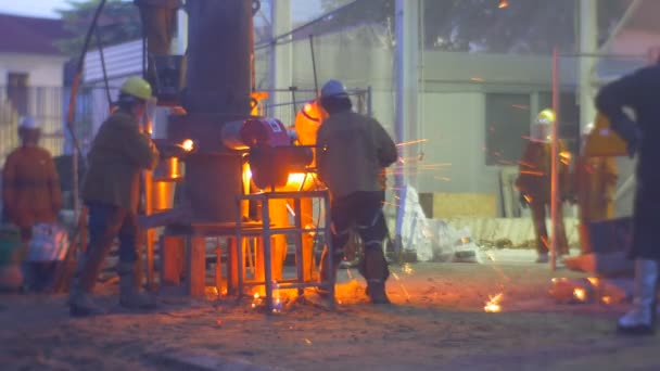 Arbetstagare runt ugnen gjutning metallgjuterier utomhus Festival av höga temperaturer i Wroclaw City Polen personer är i säkerhet kläder och hjälmar — Stockvideo