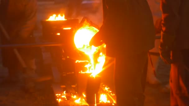 Trabalhadores Lit by Liquid Metal derramando-o em moldes à noite Cityscape Casting a Metal Silhouettes Foundry Exterior Show no Festival de altas temperaturas — Vídeo de Stock