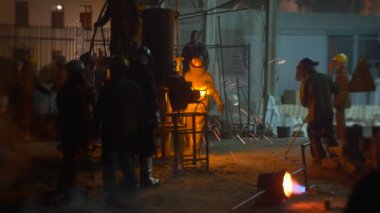 Wroclaw, Polonya - 18 Haziran 2016: Wroclaw City, Polonya 'da Yüksek Sıcaklıklar Festivali. Foundry Outdoor 'da zanaatkarlar. Erkekler metali şekillendiriyor ve Ladle 'a döküyor. Kıvılcımlar uçuşuyor