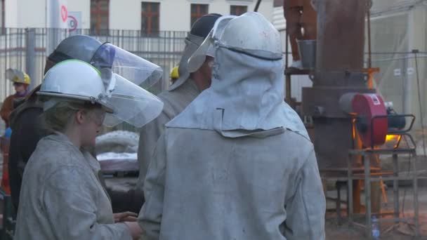 Festival of High Temperatures in Wroclaw Polonia Hombres Mujeres en el taller de fundición Trabajadores al aire libre alrededor del horno La gente está observando el proceso industrial — Vídeo de stock