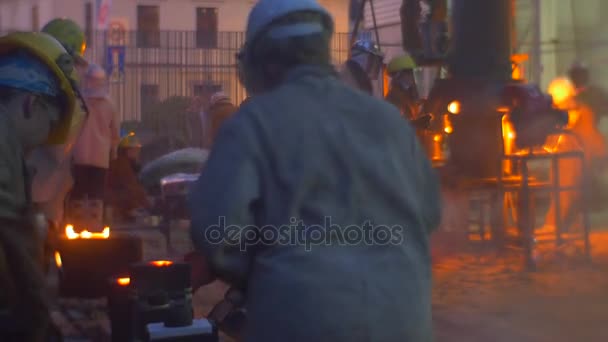 Festival der hohen Temperaturen Wroclaw Polen Menschen in Arbeitskleidung formen ein Metall Outroors in Abendsilhouetten in der Nähe der Ofenarbeiter Teilnehmer — Stockvideo