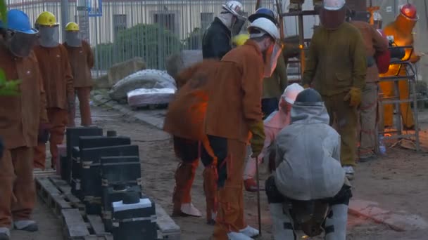 Festival delle alte temperature a Breslavia I lavoratori stanno tenendo un mestolo con camminata di ferro liquido intorno al forno La gente sta guardando il processo industriale — Video Stock