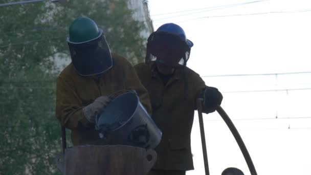 Festiwal wysokich temperatur w Wroclaw Casting warsztat na zewnątrz człowiek dodaje suchy paliwa do pieca osób linienie metalu w piecu zagranicznych rzemieślników branży — Wideo stockowe