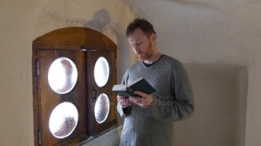 Yüksek sesle okuma yürüyüş oda meditasyon Ortodoks Kilisesi manastır küçük ahşap pencere çerçeve penceresi ile bir İncil'de O'nun el mümin, biri