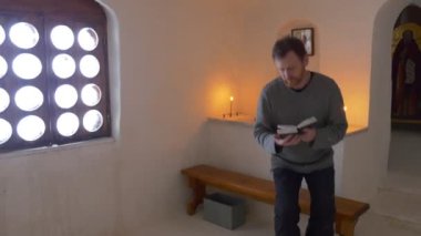 Adam ile İncil oturan kilise tebeşir mağara simgeler mum adam kalkar okuma Absorbedly tur Svyatogorsk turizme Ukrayna'da bir tezgah turist üzerinde