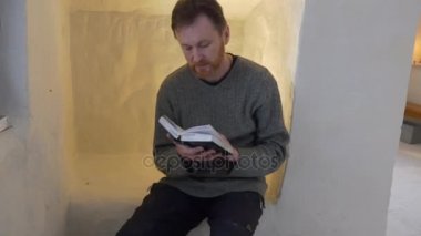 Adam İncil turist tebeşir mağara kilise Şapel Ukrayna Svyatogorsk turizm için tebeşir mağara kapı kapı tur içinde oturan kutsal kitap ile okuma
