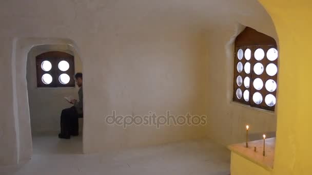 Homme avec une Bible Asseyez-vous seul Touriste dans la chapelle de l'église À l'intérieur de la grotte de la craie Images religieuses Croix Décoration dorée Tour à Svyatogorsk Tourisme en Ukraine — Video