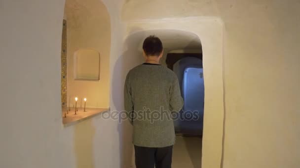 Man lyser vägen med ljus mörka korridoren grotta kloster turist i kyrkans kapell inuti krita Cave vita väggar turen till Svyatogorsk turism Ukraina — Stockvideo