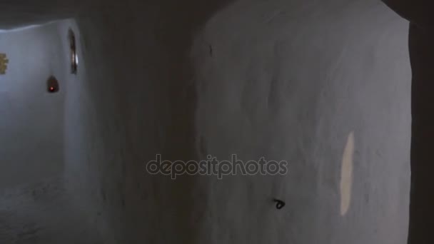 Corredor largo blanco en la roca cretácea El turista está leyendo un libro sagrado en la capilla de la iglesia Dentro de la cueva de tiza Tour a Svyatogorsk Turismo en Ucrania — Vídeos de Stock