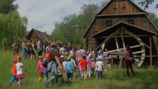 Den dětí v Opole etnografické muzeum děti učitelé rodiče na výlet, při pohledu na staré dřevěné vodní mlýn chaty Park staré polské architektury — Stock video