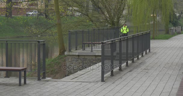 Hoher dunkelhaariger Mann sitzt auf einer Bank — Stockvideo