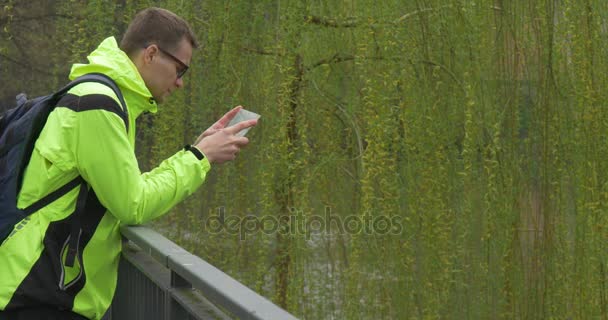 Een volwassen Man staat op een brug — Stockvideo