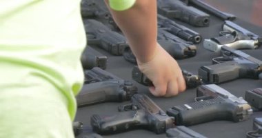 Exhibits of a Museum of Fire-Arms Lie on a Wide Black Table. Here There Are Pistols With Plastic and Wooden Handles, Six-Shooters, Long-Range Automatic Rifles. All This Weapon Has Been Exposed on a General Review During Celebrating of Day