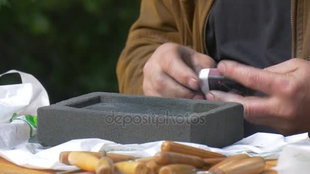 Hantverkaren Lits en rökare Tube slipning en mögel som arbetar med handhållna verktyg Festival av höga temperaturer i Wroclaw mannens händer mannen i läder jacka — Stockvideo