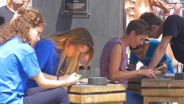 Festival der hohen Temperaturen in Breslau junge Leute, die sich als Handwerker bei der Herstellung von Gussformen versuchen, die ein Muster prägen — Stockvideo