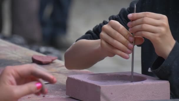 Las manos de los jóvenes preparando moldes de fundición estampado con clavos artesanos haciendo patrón en un festival de piezas de metal de alta temperatura en Wroclaw — Vídeos de Stock