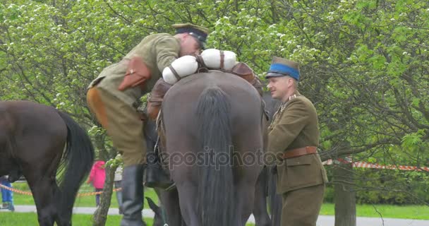 Żołnierz Opole dnia flagi Rzeczypospolitej Polskiej pobiera na koń mężczyzna żołnierzy na łące zawodnicy jadą konie paradą ludzie w autentyczne Vintage Odzież uniformowa wojskowa — Wideo stockowe