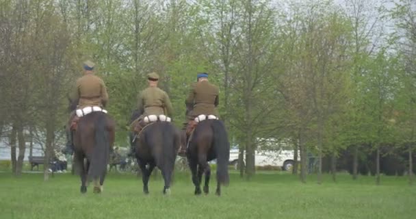 ヴィンテージ軍第二次世界大戦の兵士の軍服でライダー グリーン メドー公園に屋外パレード状態の休日の祭典を離れて馬に乗っています。 — ストック動画