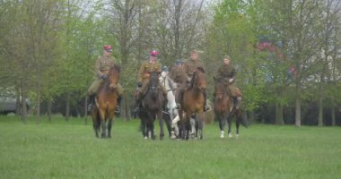 Opole, Poland - May 02 2016: Polish Flag Day in Opole. Soldiers, Riders Perform Formation While Riding on Horses, Kids in Safety Helmets Are Riding, Soldier Looking After Kids