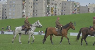 Opole, Poland - May 02 2016: Polish Flag Day in Opole. Soldiers, Riders Perform Formation While Riding on Horses, Kids in Safety Helmets Are Riding, Soldier Looking After Kids