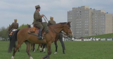 Opole, Poland - May 02 2016: Polish Flag Day in Opole. Soldiers, Riders Perform Formation While Riding on Horses, Kids in Safety Helmets Are Riding, Soldier Looking After Kids