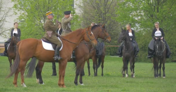 Dnia flagi Rzeczypospolitej Polskiej w Opolu kawalerii jest jazda konna konie mężczyzn i kobiet stojących w linii na łąka wietrzny dzień spódnice są macha mężczyzn w jednolitych prób Vintage — Wideo stockowe