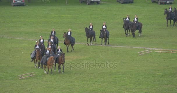 Oppelner Stadtfest Pferderegiment reitet auf der Wiese Vorführungen auf der grünen Wiese Reiter treten auf braunen Pferden auf Frauen in schwarzen langen Kleidern — Stockvideo