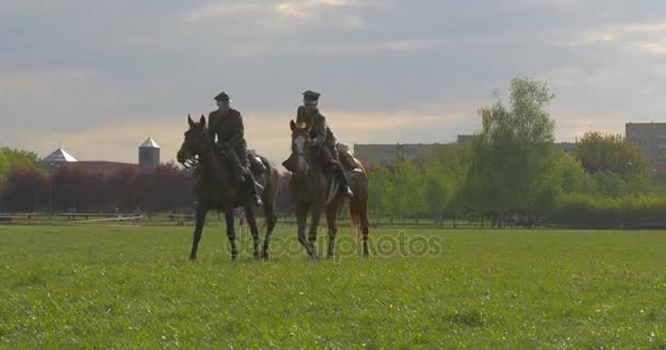 Jour de la ville d'Opole Deux cavaliers en uniforme vintage Soldats au défilé au printemps ensoleillé Jour sur prairie Les gens marchent dans le parc sur fond Paysage urbain — Video