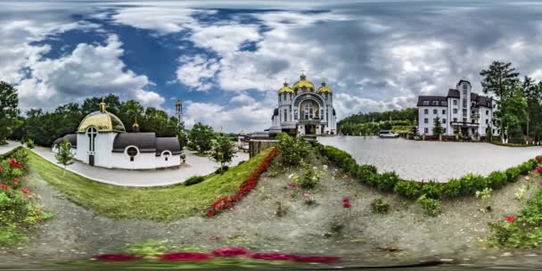 360 vr videóinak hívek a templomban a Zarvanytsia görög katolikus templom virág ágyak közelében vallási épületek gyönyörű látvány a napsütéses nyári nap turizmus — Stock videók