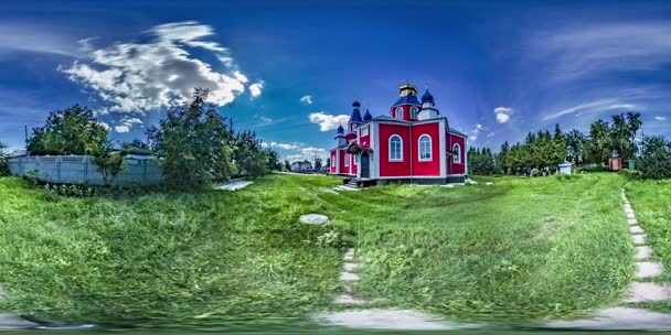 360 vr Video ortodoxa kyrkan på landskap solen skiner ljust grönt gräs molnen på blå himmel byggnaden är målade i rött gyllene kupoler på toppen av en — Stockvideo