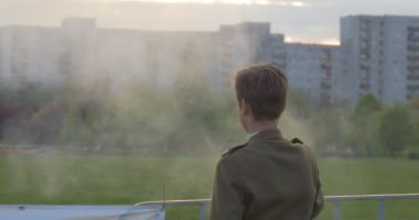 Genç sarışın adam yangın kollarından hedefliyor