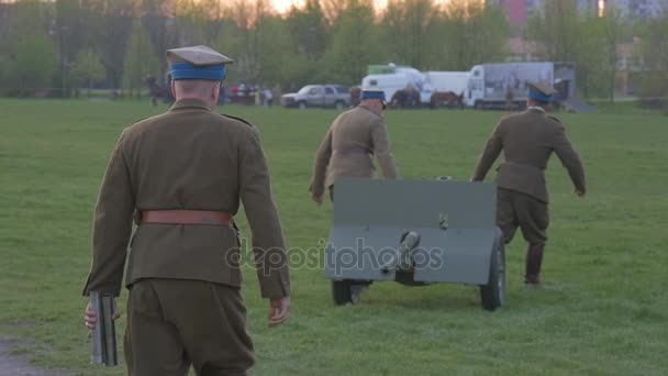 Két felnőtt ember hordoz egy nehéz géppuska — Stock videók