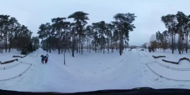 Slavutich, Ukraine - Jan 15 2017: 360 vr Video 360 Degrees. Christmas Eve in Slavutich. Family Walks in City Park in Winter. People Walk With Their Children on a Sleigh, Spend Wintry Holidays, Dusk. Pines and Other Trees Are Around. Non Residential