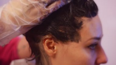 İstemcinin baş örtülü ile boya Haircolor stilist mesajlaşma ev ya da Salon saç boyama berber eller müşterinin gözleri çoğu kapalı stilist eldiven olduğunu