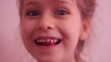 Çocuğun diş mutlu kız gevşek bebek dişle ilgili ince iş parçacığı üzerinde tutuyor ve çocukça bir fantezi gülen İlköğretim diş gevşek diş perisi çocuk hayal