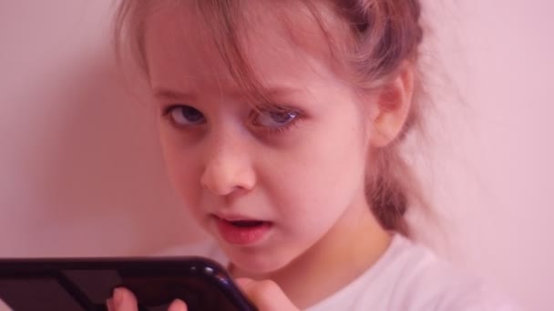 Μικρό παιδί παίζει με Smartphone και χαμογελώντας κόκκινα μαλλιά κορίτσι φακιδωμένος έχει διασκέδαση μένει σπίτι νεογιλών δοντιών χαλαρά νεράιδα παιδί φαντάζεται την παιδιάστικη φαντασία — Αρχείο Βίντεο