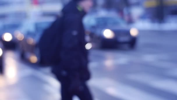 横断歩道のヘッドライトの前に止まった横断車に人々 のシルエットの群衆がピント濡れた忙しい道路上の歩行者へ変更 — ストック動画