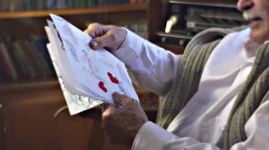 Kıdemli adam gösterir çocuk çizimleri Birleşik aile Dede tatlı anılar Vintage iç in adamın evi sıcak Cosy Oda mutlu yaşlı adam tarafından çevrilidir