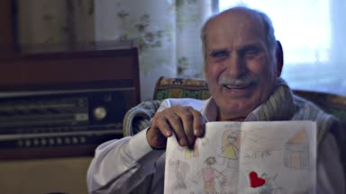 Çocuk ailesiyle birlikte Vintage Odası telgraf toplanan çocuğun çizimleri tutarak ve onun torunları ziyaret bekliyor gülüyor Dede hatırlar