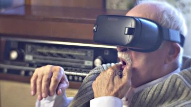 Adam mendil O'nun bıyık dönüm içinde vr kulaklık Video izlerken eski mesajı merak bir arka plan bir kez adam seçer Modern cihazları üzerinde başkanıdır