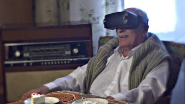 Avô no vr Goggles descreve o que ele vê assistindo vídeo incrível e ligação de maravilha de vezes móveis antigos lugar silencioso pedaço de bolo em uma mesa — Vídeo de Stock