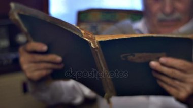 Sahne kıdemli adam ile eski kitap emeklilik emeklilik anılar, gençlik buruşuk adamın yüzüne dokunmadan gülümseyen Sayın saygı büyükbaba 80 yıl yaşında