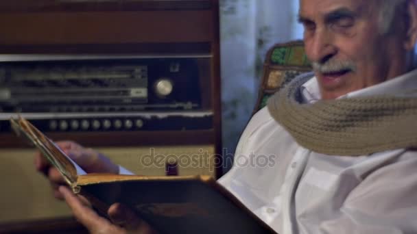 Homem de Envelhecimento Procurando Felicidade em Fotos Lendo Livro Antigo e Folheando Através de Papéis Memórias de um Velho Valores Familiares Avô 80 Anos em Casa — Vídeo de Stock