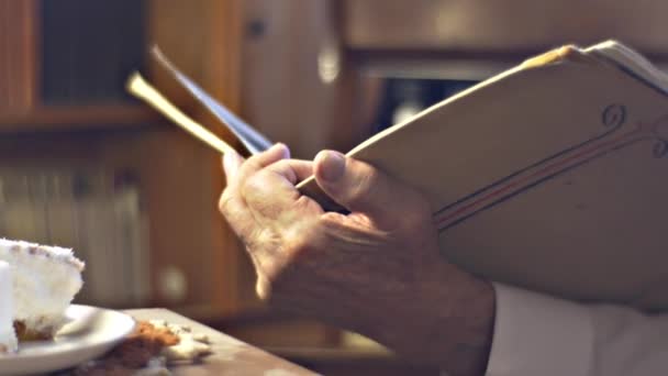 Alter Mann liest beim Mittagessen Jahrgangstasse und Teller Mann von intelligentem Beruf liebt Lesen Arzt Wissenschaftler freundlich Großvater hält sein Gehirn jung — Stockvideo